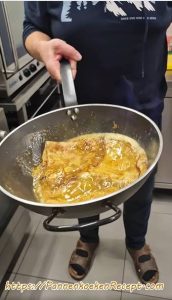 Crêpes Suzette in de pan tijdens het flamberen met likeur