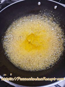 Sinaasappelzeste die meekookt in de sinaasappelsaus voor Crêpes Suzette